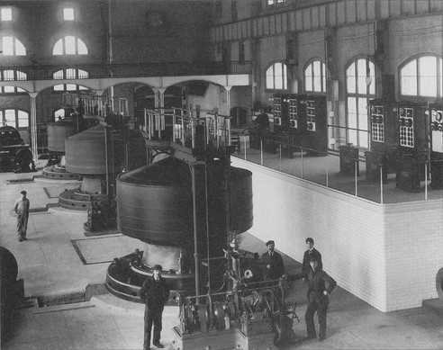 Workers pose near a Westinghouse-Tesla generator in the Edward Dean Adams power station.