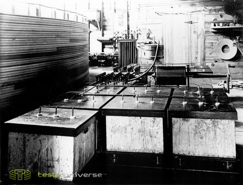 View of interior, chiefly showing condensers, break motor and regulating coil in primary of oscillator. Westinghouse high tension transformer, supply transformers and arresters in background.